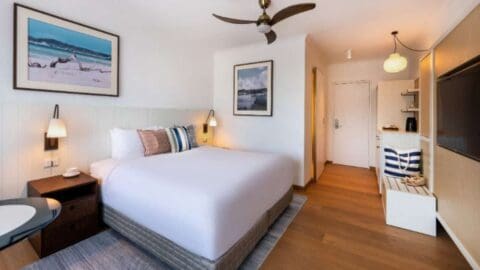 A maritime inspired hotel with a large bed in the center of the room.