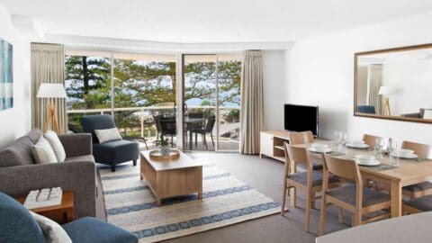 A large room with sea views, living room furniture, a large dining table.