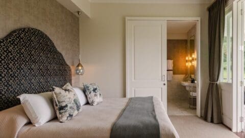 A luxurious ensuite bedroom in beige brown colors.