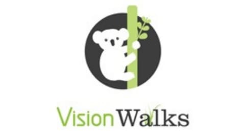 Logo of VisionWalks featuring a white koala climbing a tree, set against a black circle background, with the text "Vision Walks" below. This symbolizes our dedication to ecotourism and responsible tours.