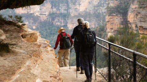 The people walking on a path carved in the mountain.